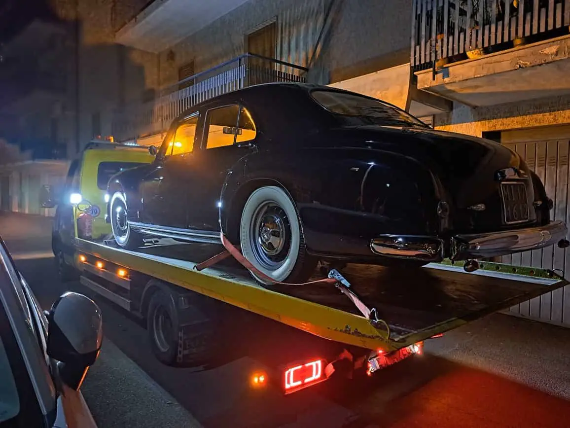 Auto d'epoca nera caricata sul carroattrezzi di notte